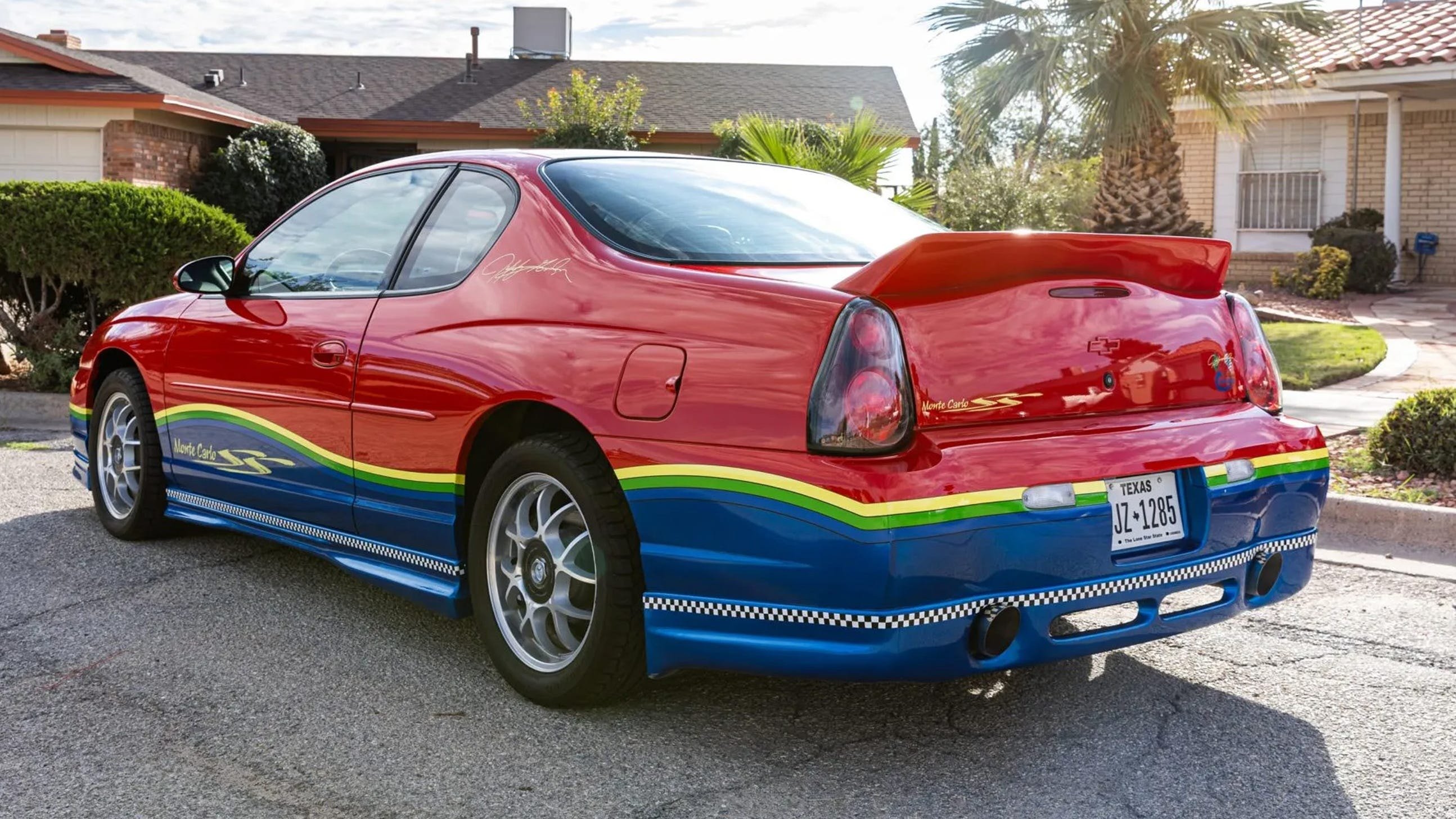 3/4 bakre hörn, blå underdel av karossen, flerfärgade ränder, spoiler, Texas-registreringsskylt.