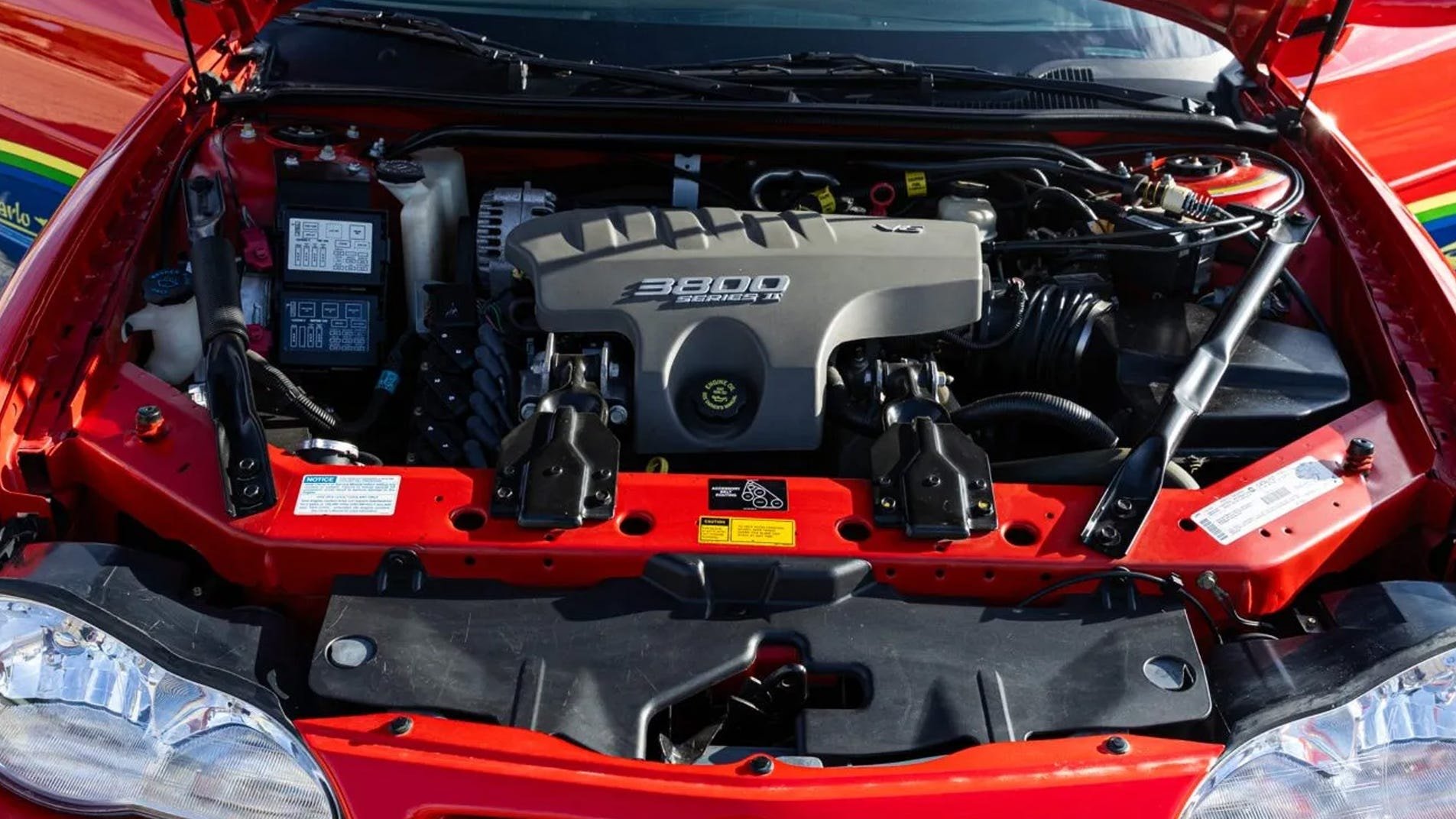 V6 3800 Serie II 3,8 l motorrum, motorhuv öppen, batteri synligt.