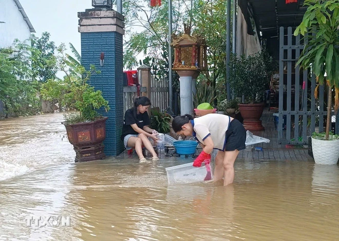 ہیو کے رہائشی سیلاب کے بعد اپنے گھروں کی صفائی میں مصروف ہیں۔ (تصویر: Hai Au/VNA)