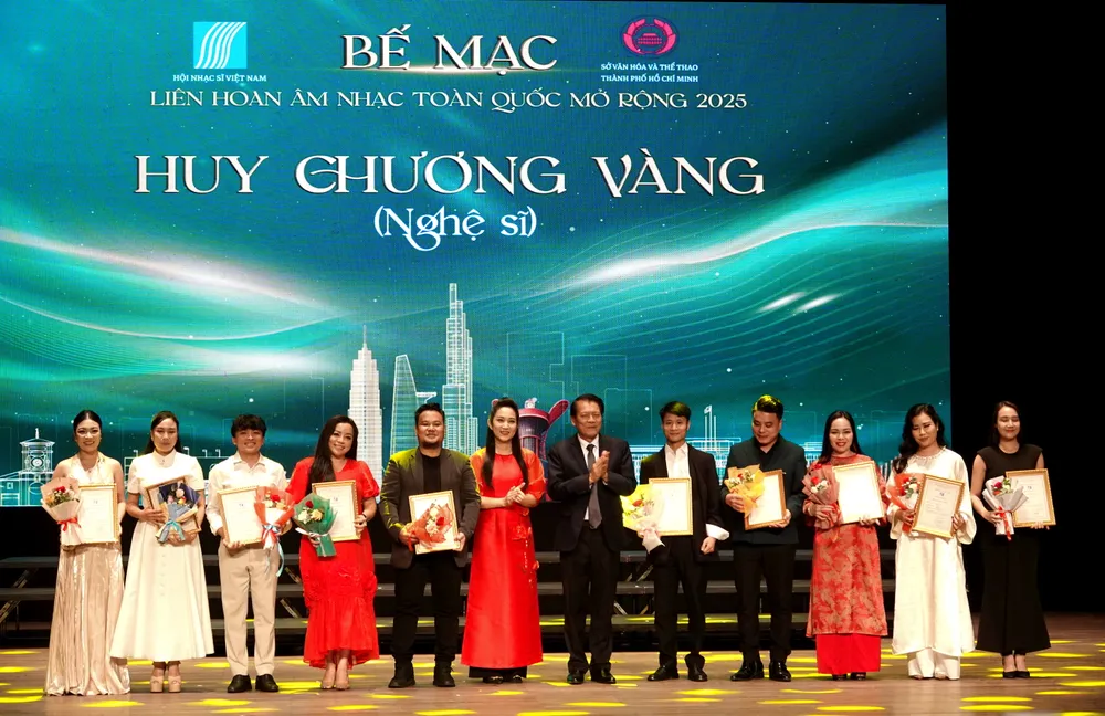 हो ची मिन्ह सिटी के संस्कृति, खेल और पर्यटन विभाग की उप निदेशक गुयेन थी थान थुय और लोक कलाकार-संगीतकार गुयेन क्वांग विन्ह ने 2025 के राष्ट्रीय मुक्त संगीत समारोह में उत्कृष्ट प्रदर्शन करने वाले कलाकारों और गायकों को स्वर्ण पदक प्रदान किए। फोटो: थुय बिन्ह