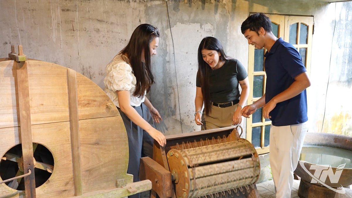 विदेशी पर्यटक चावल कूटने की मशीन का आनंद लेते हैं।