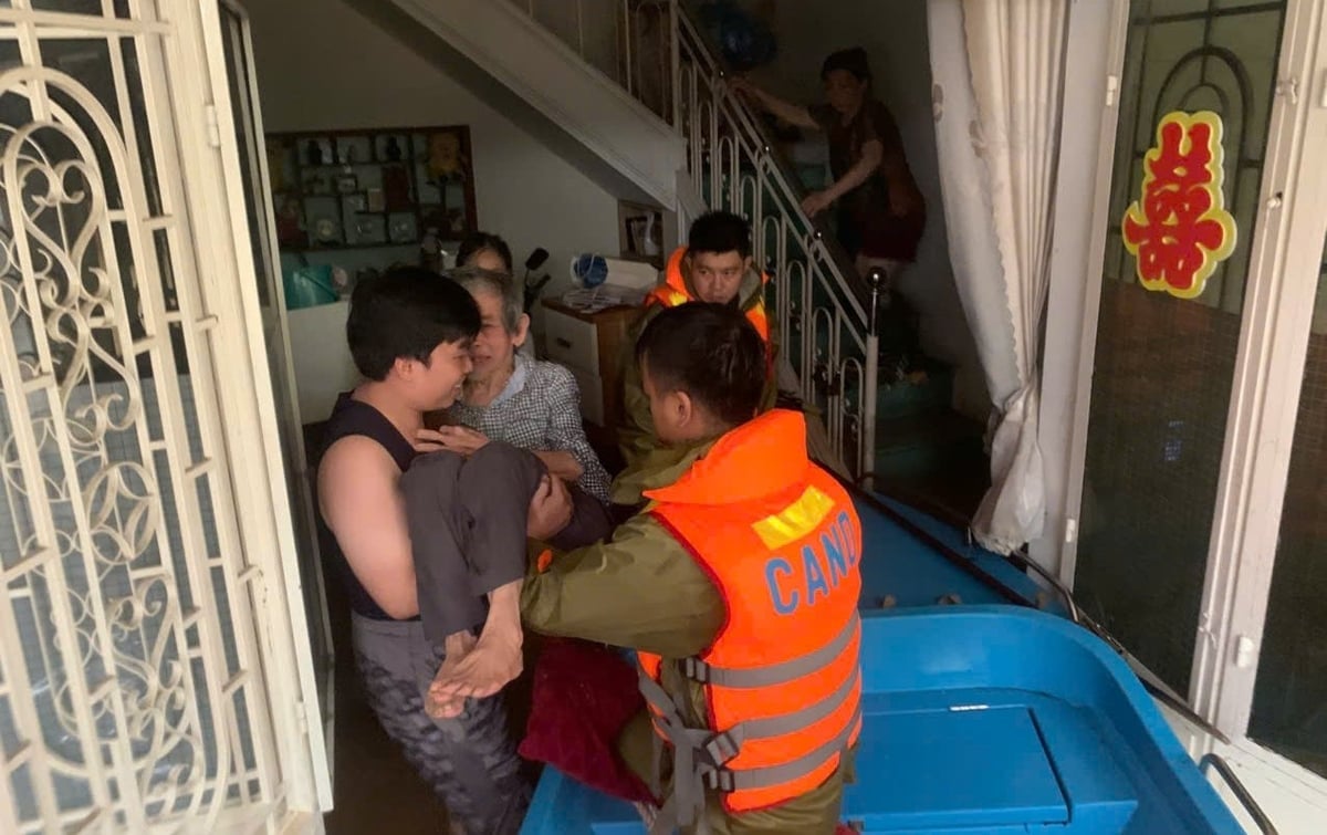 Lực lượng công an đưa người già đến nơi an toàn. Ảnh: Văn Dinh.