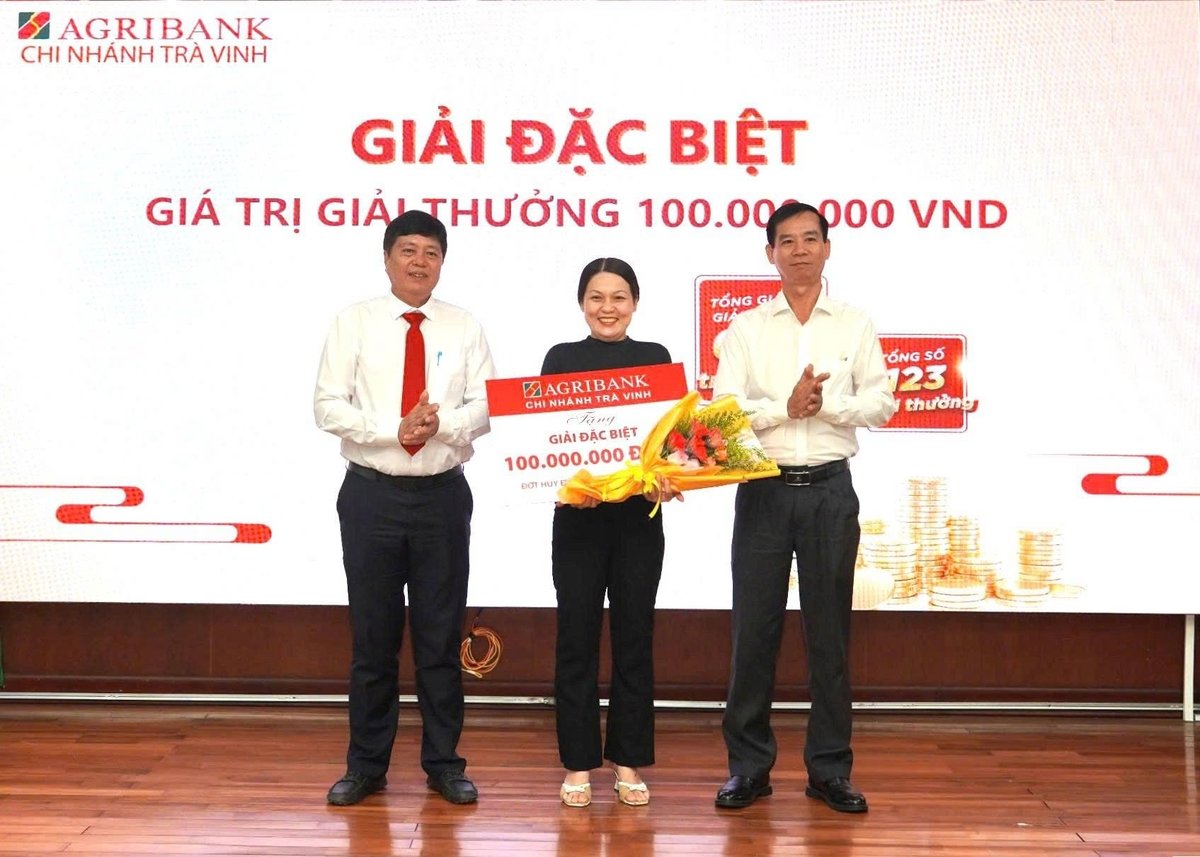 Ông Lê Văn Hai - Phó Giám đốc Ngân hàng Nhà nước Khu vực 14 (bên phải) và ông Phạm Văn Thái - Giám đốc Agribank chi nhánh Trà Vinh trao thưởng cho khách hàng trúng giải Đặc biệt. Ảnh: Minh Khương.