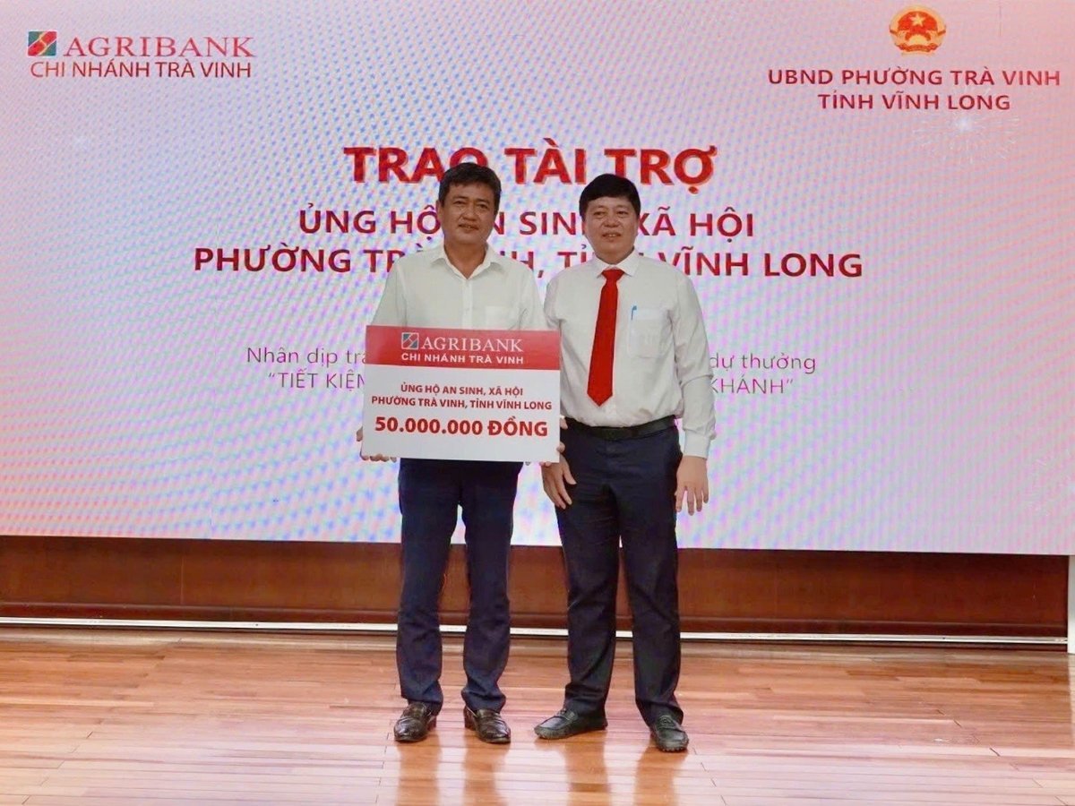 Ông Phạm Văn Thái (bên phải) - Giám đốc Agribank chi nhánh Trà Vinh trao 50 triệu đồng an sinh xã hội cho đại diện chính quyền địa phương. Ảnh: Minh Khương.