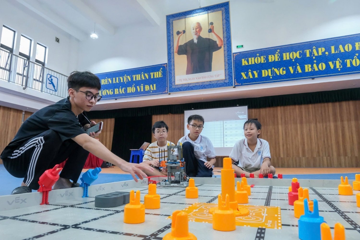 Tras finalizar la clase, los estudiantes se quedaron charlando animadamente sobre la idea de un robot que «sabe separar la basura» o un «robot que ayuda a las personas con discapacidad visual». Foto: Petrovietnam. Giờ học kết thúc, các em vẫn nán lại, trò chuyện rôm rả về ý tưởng robot 'biết phân loại rác' hay 'robot hỗ trợ người khiếm thị'. Ảnh: Petrovietnam.