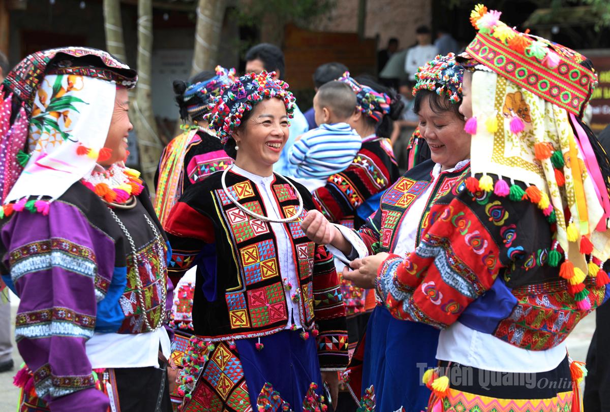 ผู้หญิงโลโลในชุดพื้นเมืองสีสันสดใส กำลังโต้ตอบกันในงานเทศกาลวัฒนธรรมโลโลไช