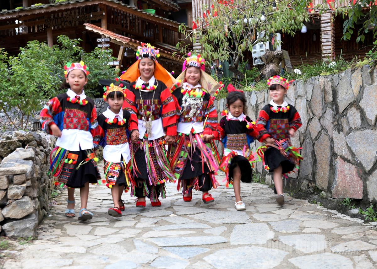 เด็กๆ เผ่าโลโลเปล่งประกายในชุดประจำชาติเพื่อร่วมงานเทศกาลวัฒนธรรมชาติพันธุ์โลโล