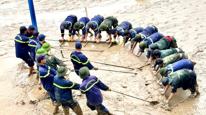 হিউ সিটির একটি স্কুলের উঠোন থেকে কাদা পরিষ্কার করার জন্য কোয়াং ট্রাই প্রাদেশিক পুলিশ বাহিনীতে যোগ দিয়েছে।