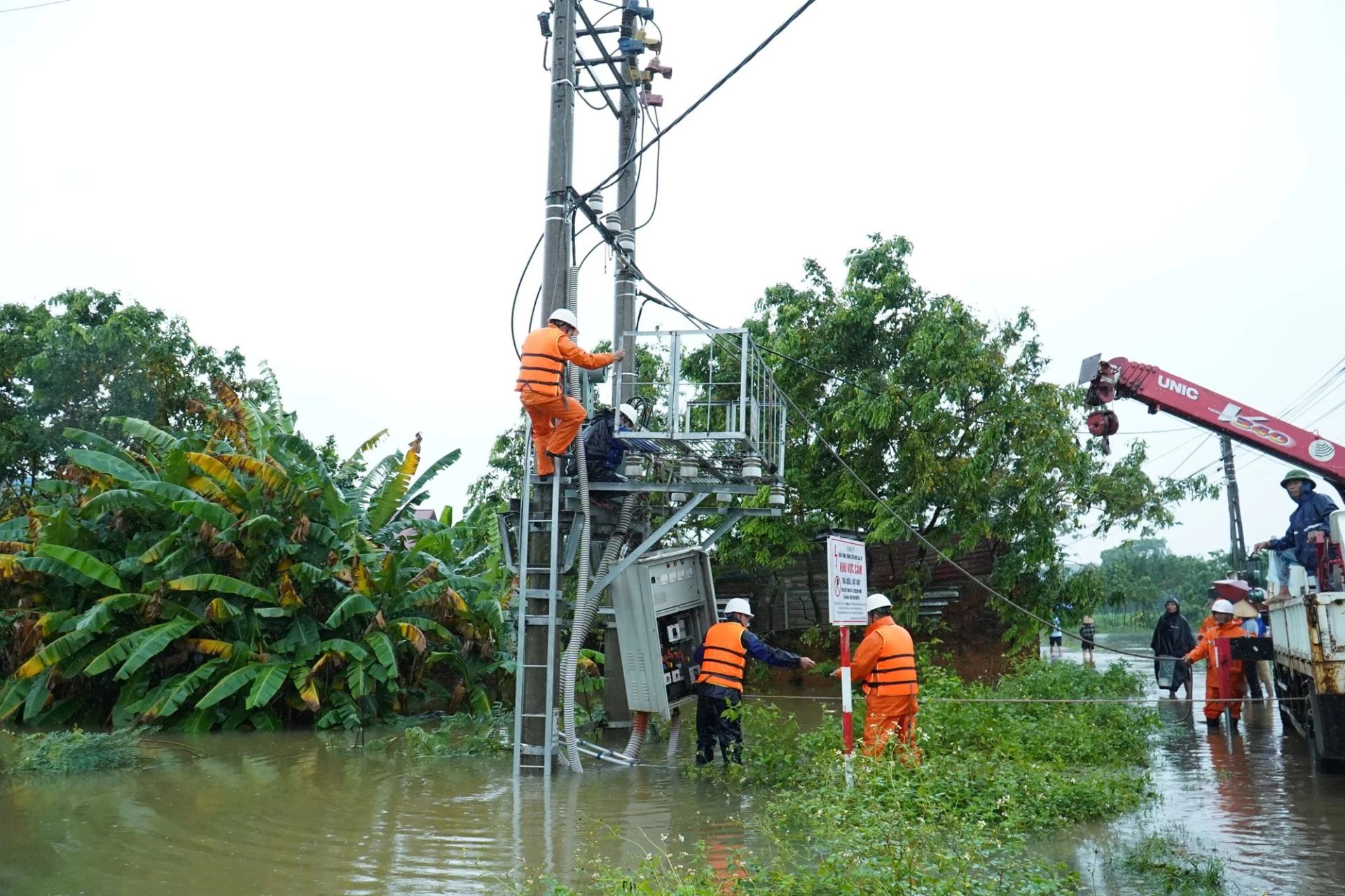 Workers try to fix power problems caused by floods.