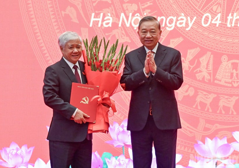 Generální tajemník To Lam předal soudruhovi Do Van Chienovi rozhodnutí politbyra a květiny k poblahopřání. (Foto: DUY LINH)