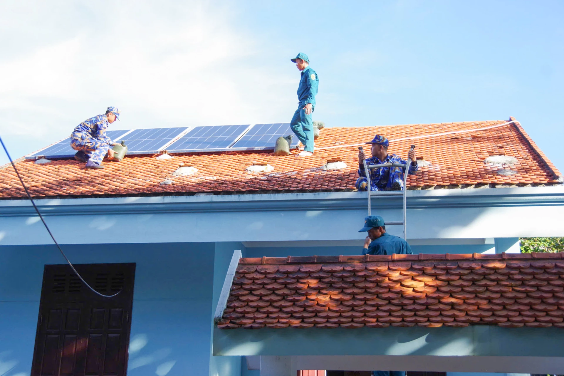 Truong Sa adasındaki subaylar ve askerler fırtına öncesinde insanların evlerini güçlendirmelerine yardımcı oluyor.