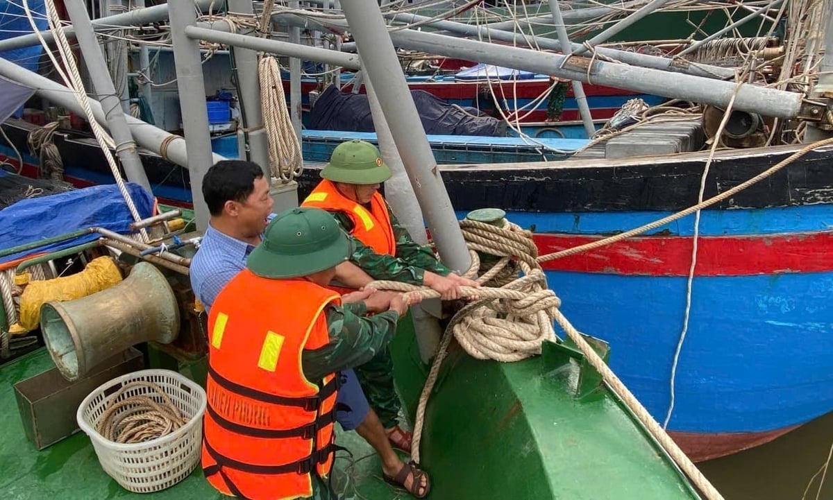 Прикордонники допомагають людям кинути якір на рибальські човни, щоб пережити шторм. Фото: Хуу Тінь. Bộ đội biên phòng hỗ trợ người dân neo đậu tàu cá chống bão. Ảnh: Hữu Tình.