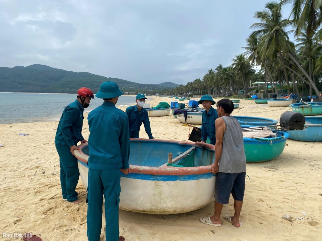 Sivil savunma güçleri, insanların teknelerini güvenli bir yere taşımalarına yardımcı oluyor. Fotoğraf: Vo Anh