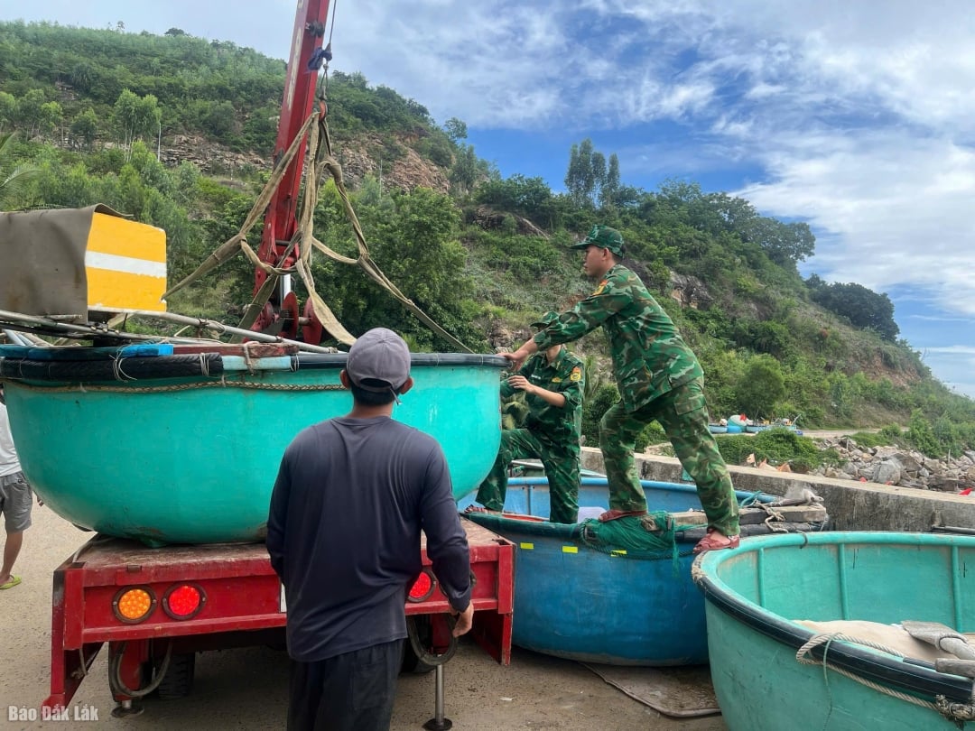 Cán bộ, chiến sĩ Đồn Biên phòng Xuân Hòa hỗ trợ ngư dân đưa thúng chai và phương tiện nhỏ lên bờ, bảo đảm an toàn trước khi bão số 13 đổ bộ.