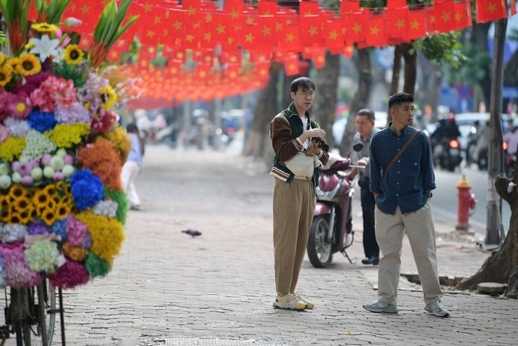 Phan Dinh Phung Street is lined with trees and falling yellow leaves typical of autumn in Hanoi.