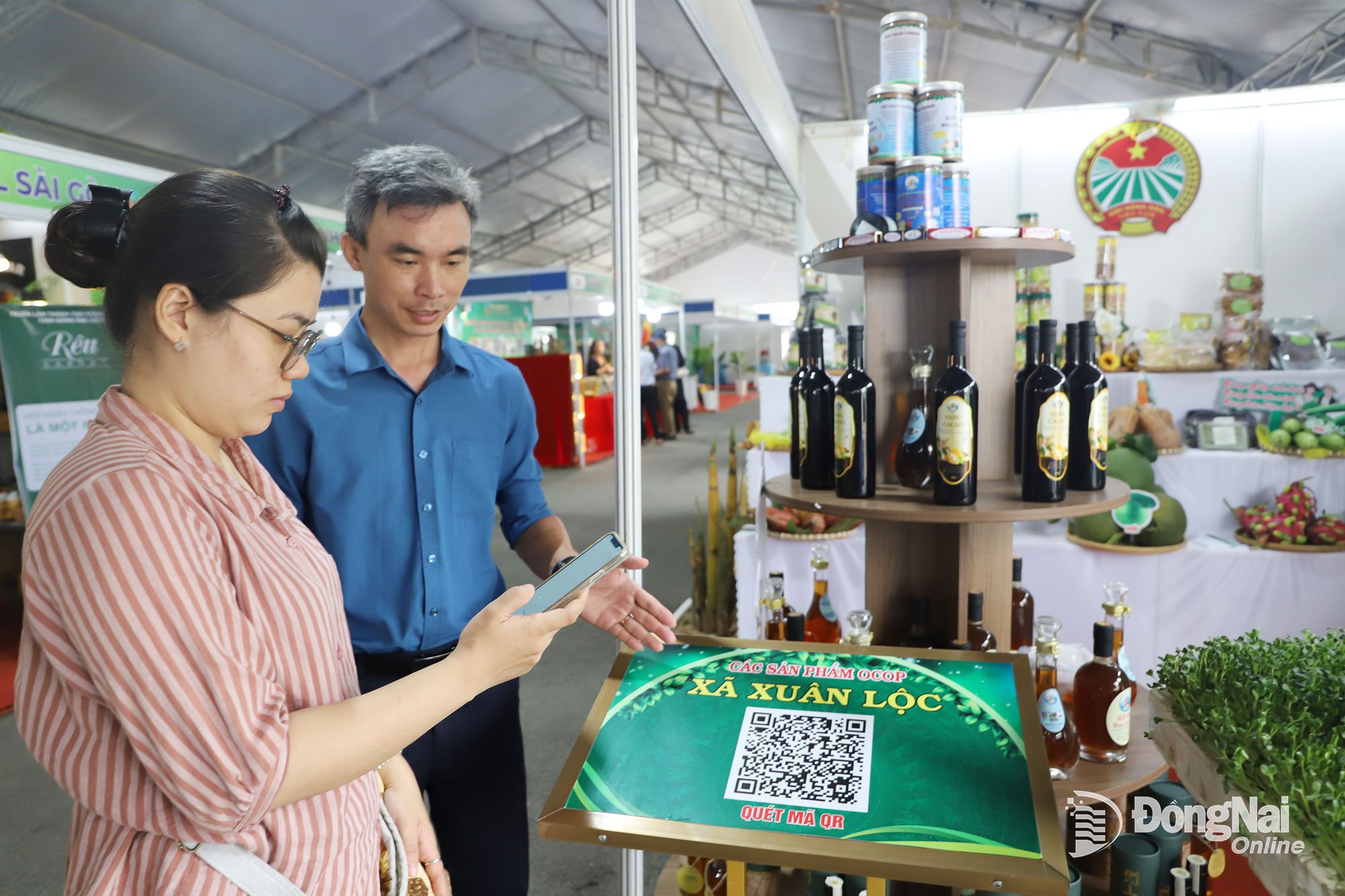 Người tiêu dùng sử dụng điện thoại thông minh để quét mã tìm hiểu thông tin về nông sản địa phương. Ảnh: Bình Nguyên

