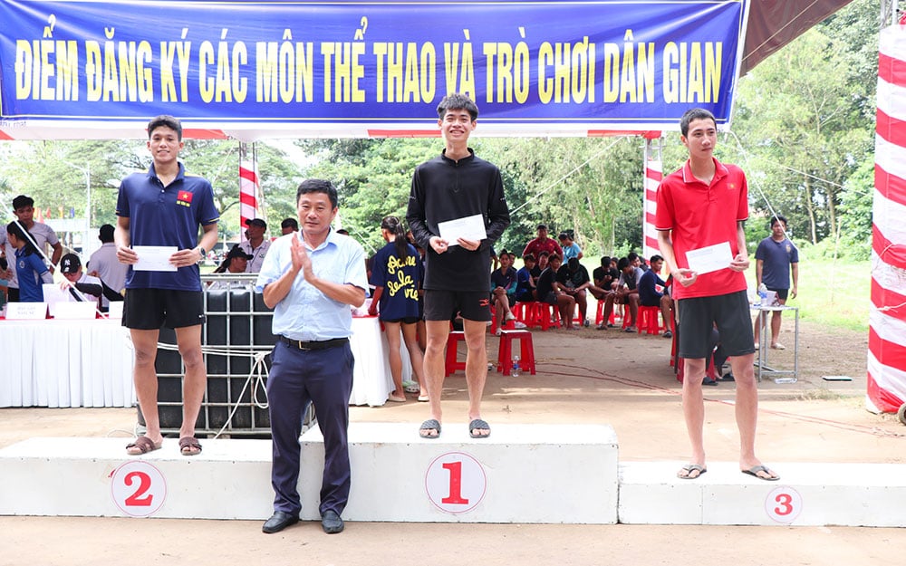 主催者は男子袋投げ競争の優勝者に賞品を授与した。