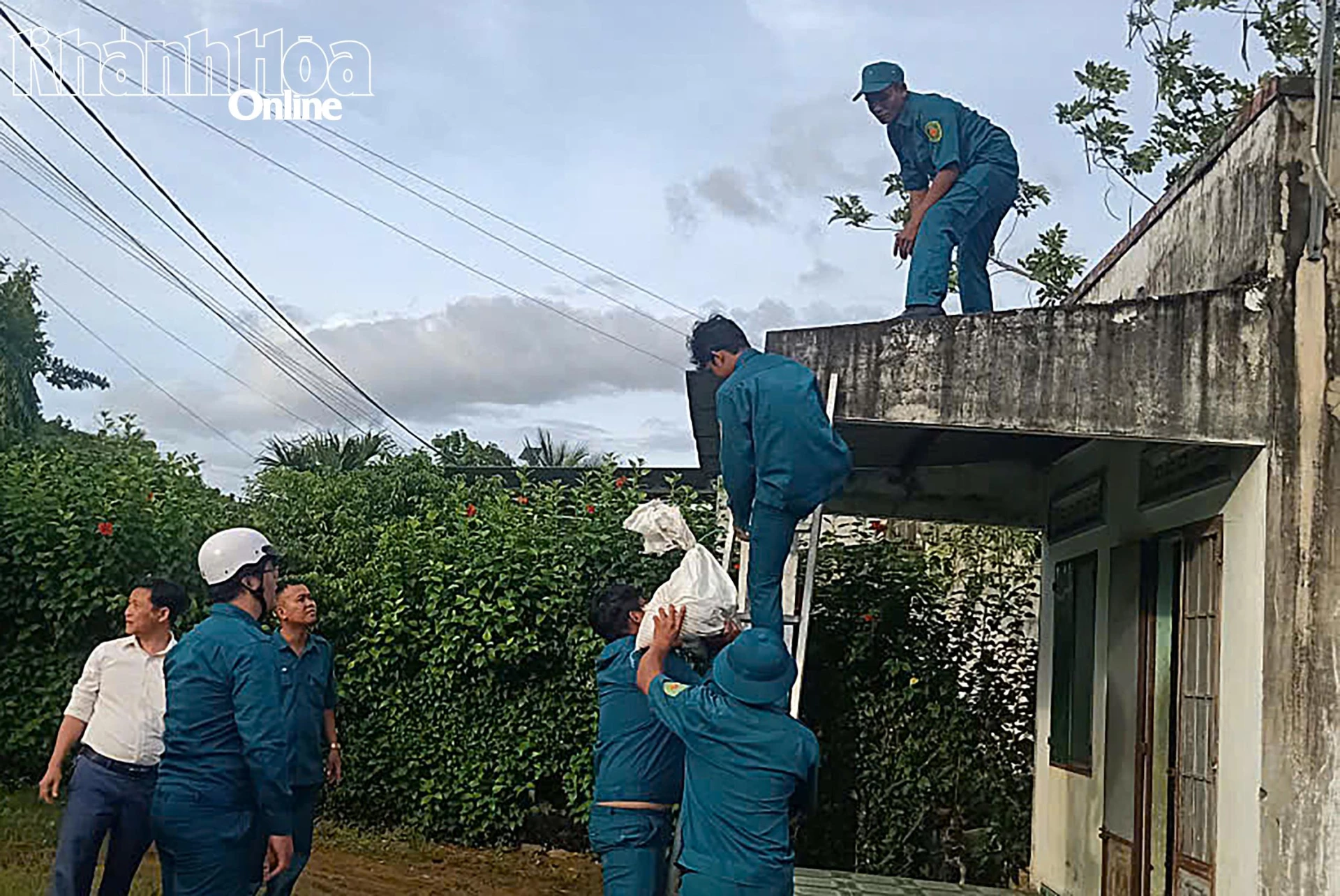 Lực lượng dân quân tự vệ xã hỗ trợ người dân chằng chống nhà cửa.