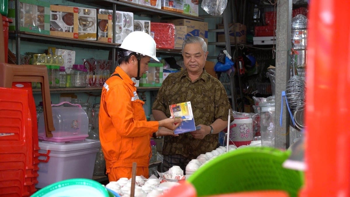 EVNSPC 직원들이 각 가구를 방문하여 우기와 폭풍우 기간 동안 안전한 전기 사용 방법을 교육하고 있습니다. 사진: 황 훙. Công nhân EVNSPC đến từng hộ gia đình hướng dẫn sử dụng điện an toàn trong mùa mưa, bão. Ảnh: Hoàng Hùng.