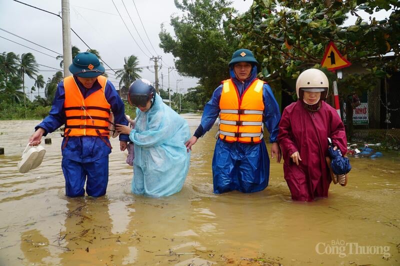 Pihak berkuasa wad Hai Van membantu orang ramai menyeberangi air dalam. (Gambar diambil pada 28 Oktober)