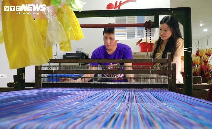 Hang veileder funksjonshemmede ansatte i bruk av nylonvevemaskiner.