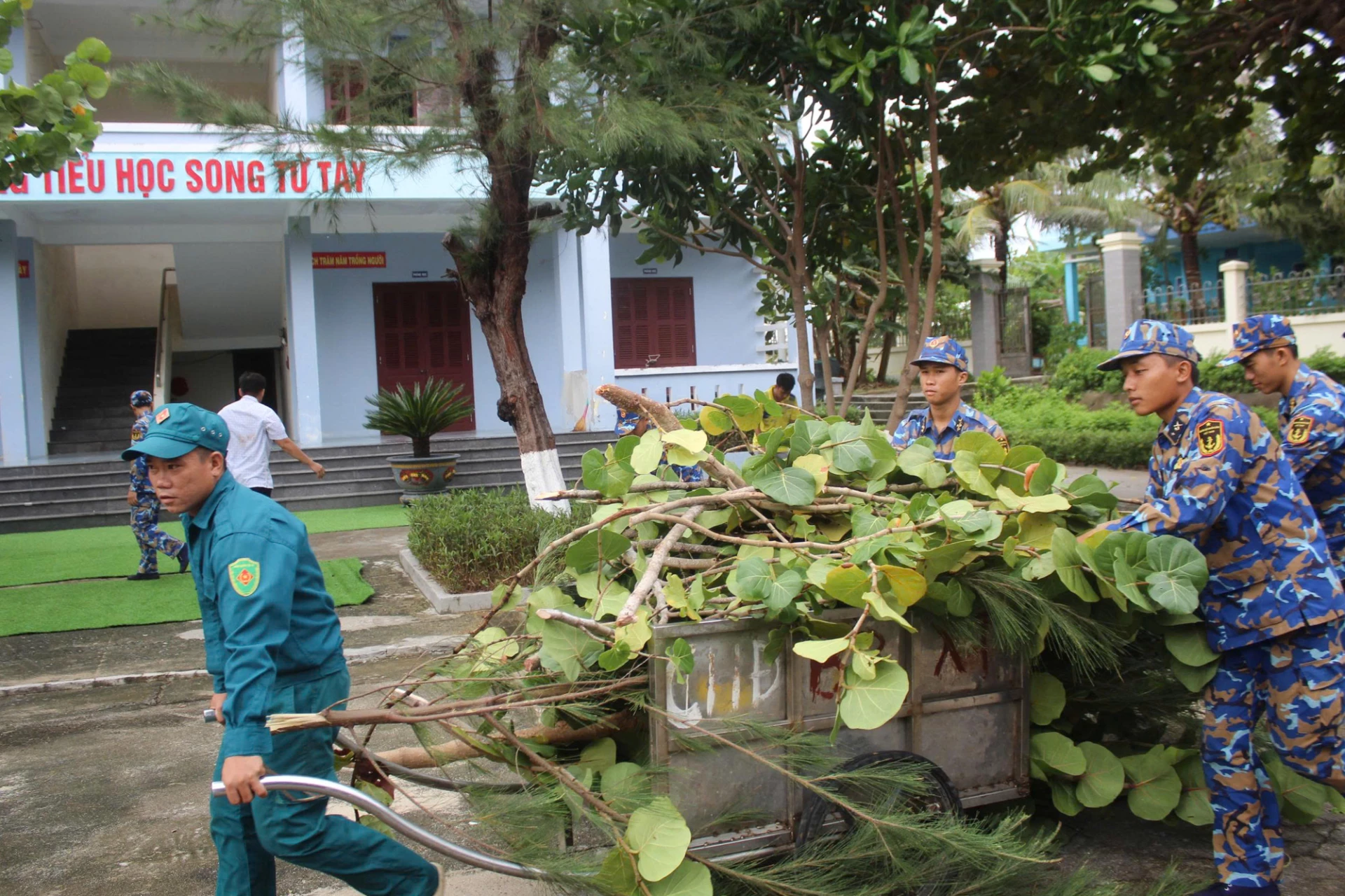 Soldiers and people of Song Tu Tay island clean up after the storm.