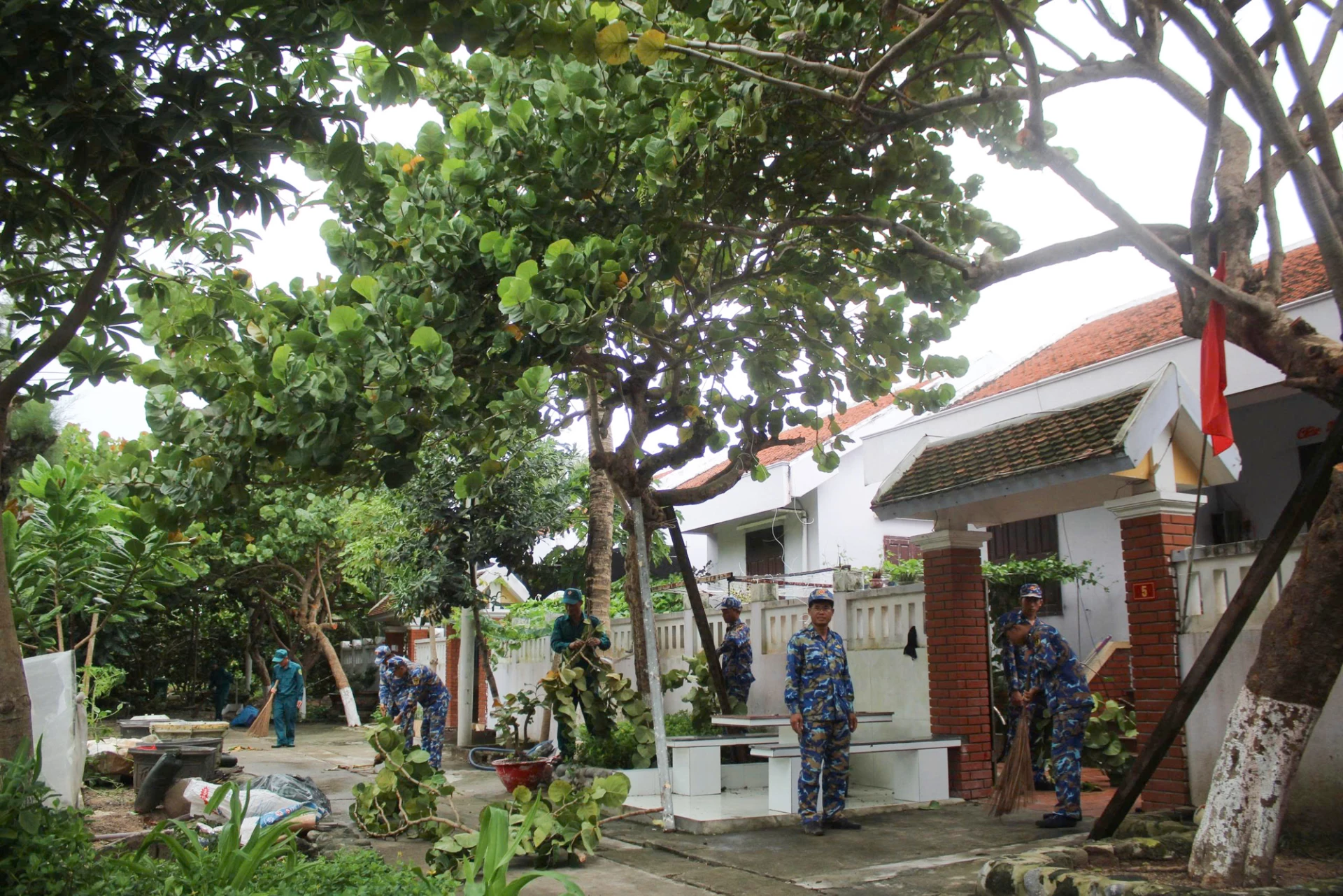 Officers and soldiers of Song Tu Tay island help people clean up after the storm.