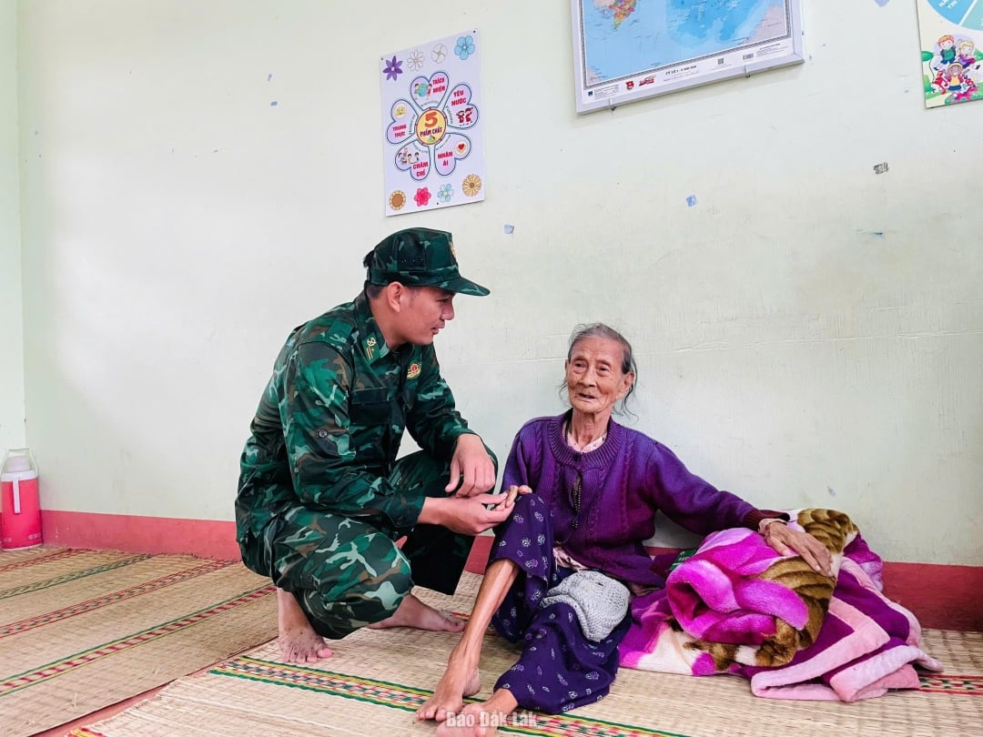 Důstojníci a vojáci pohraniční stráže Xuan Dai navštívili a povzbudili obyvatele obytné skupiny Long Phuoc v městské části Song Cau, kteří se ukrývali před bouří č. 13 v základní škole Xuan Phu. Foto: Ha My