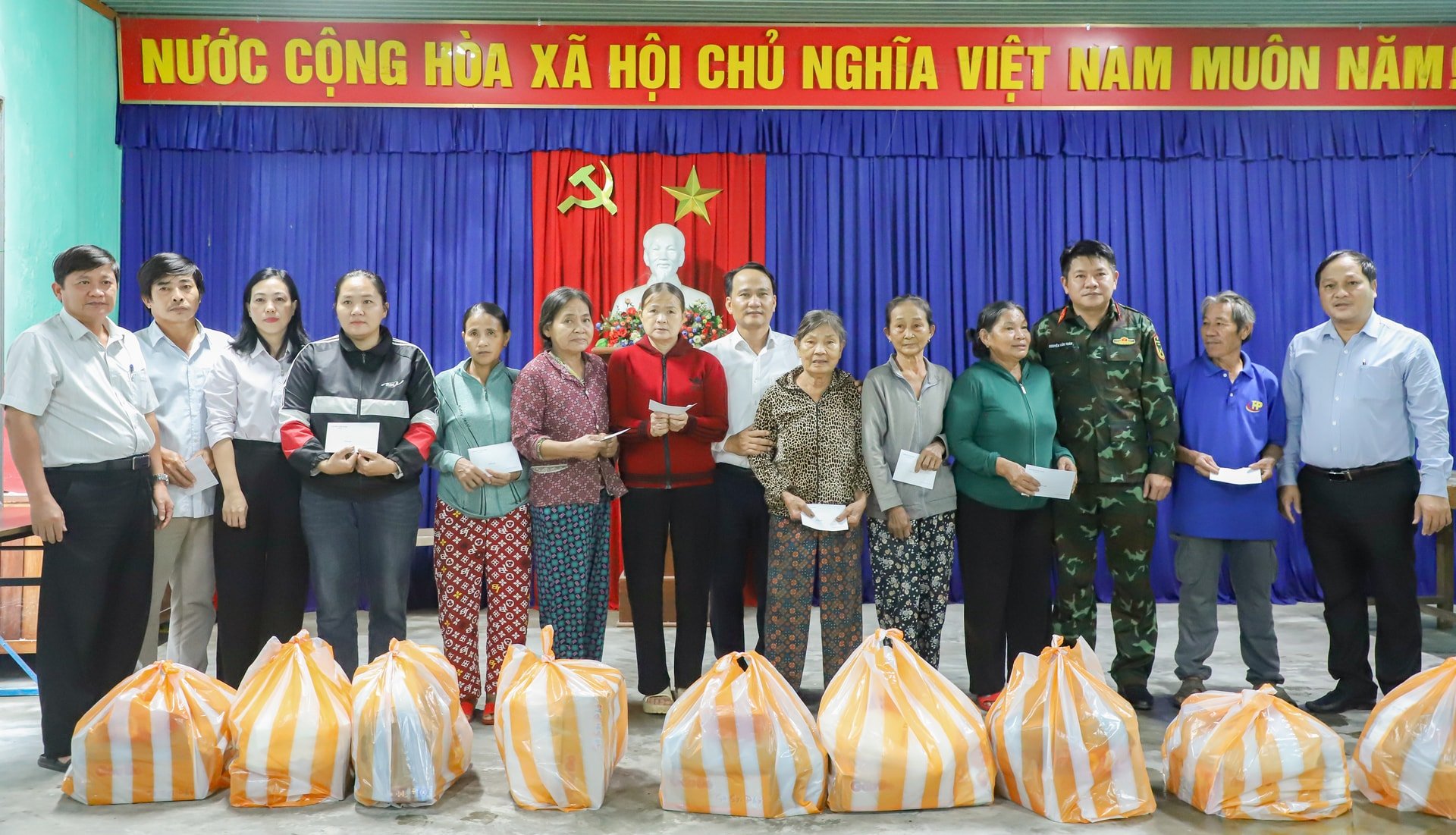 Secretarul adjunct permanent al Comitetului de Partid al orașului, Nguyen Dinh Vinh (al 8-lea din stânga), oferă cadouri pentru a sprijini locuitorii din comuna Que Son Trung. Foto: NGOC PHU