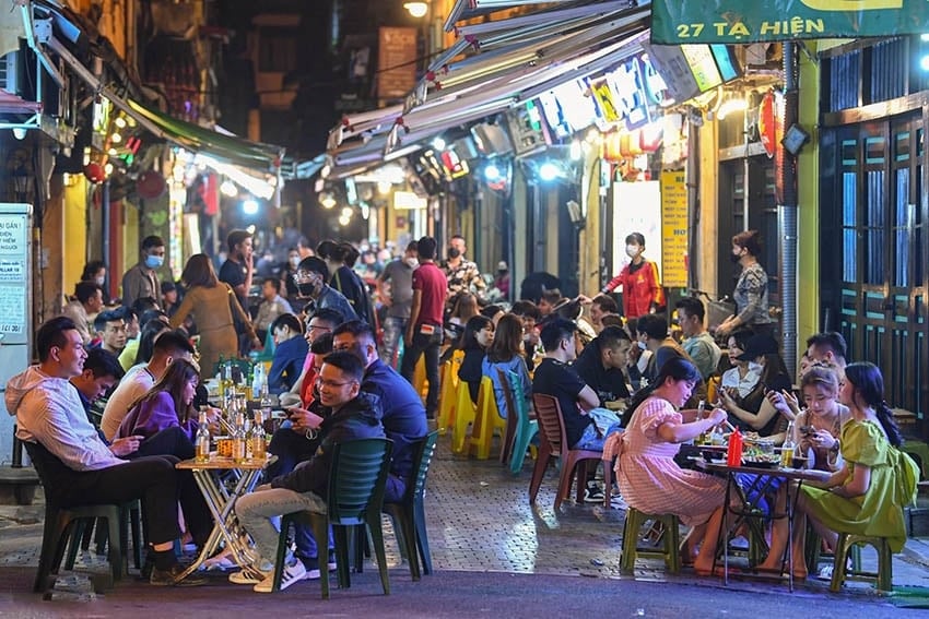 Không khí tấp nập tại một con phố ẩm thực ở Hà Nội về đêm.