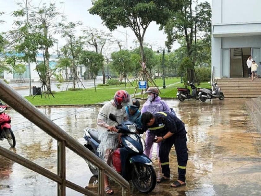 Folk kommer til Hoa Phat Dung Quat Steel Companys sovesal for å søke ly for stormen.