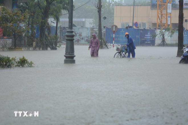 Langvarig kraftig regn og dypt flomvann har gjort det vanskelig for kjøretøy å bevege seg i Hue. (Foto: Van Dung/VNA) ttxvn-hue-ngap-sau.jpg