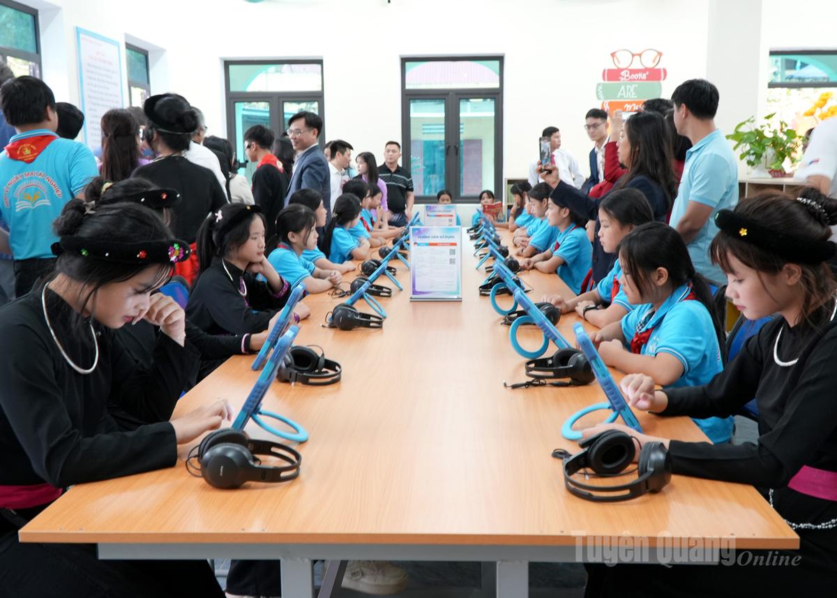 Elevii de la Școala Gimnazială Tan Trao citesc cărți electronice la biblioteca școlii.