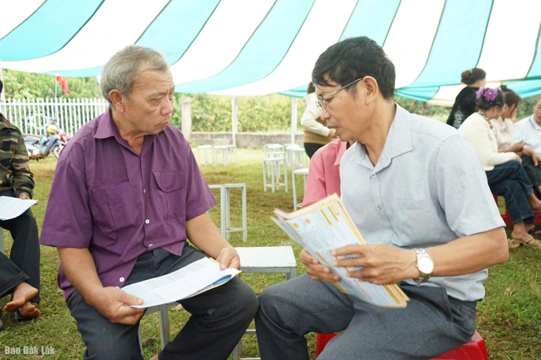 A Kroong Nang Társadalombiztosítási munkatársak az egészségbiztosítási kötvényeket terjesztik az emberek körében.
