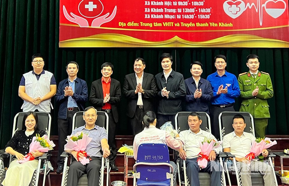 ผู้นำกาชาดและผู้นำท้องถิ่นถ่ายรูปเป็นที่ระลึกร่วมกับอาสาสมัคร