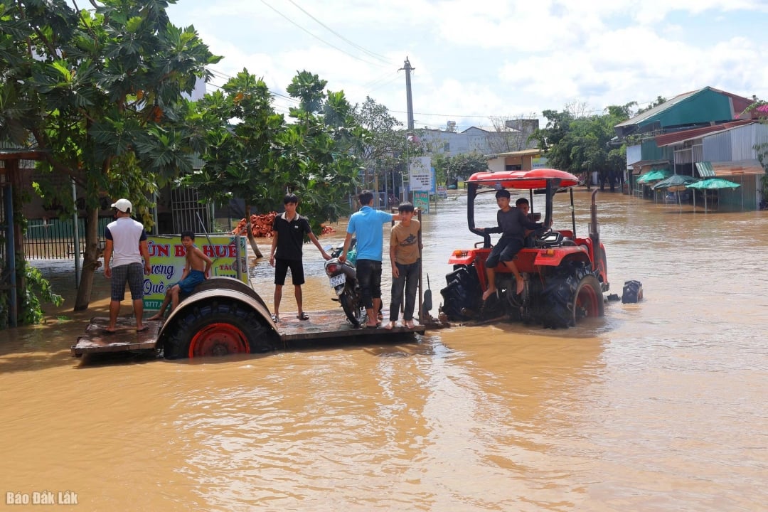 ប្រជាពលរដ្ឋធ្វើដំណើរតាមត្រាក់ទ័រឆ្លងកាត់តំបន់លិចទឹក។