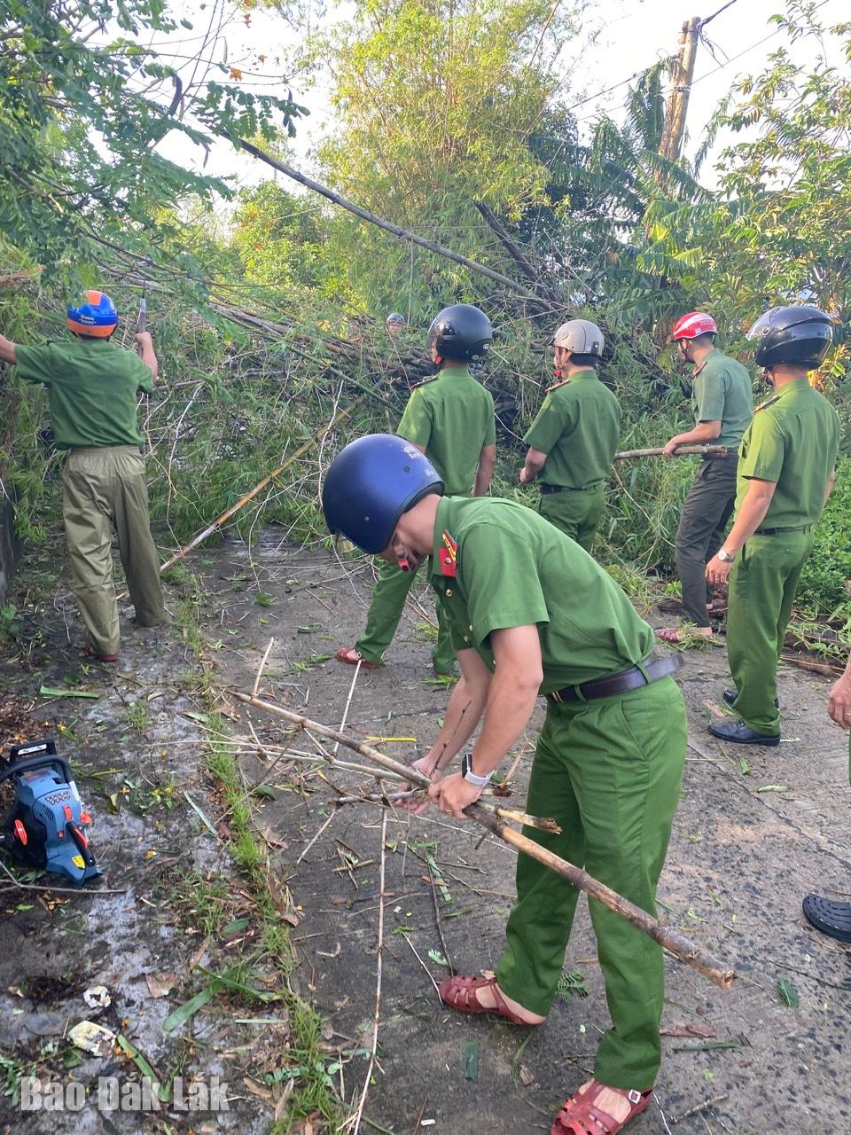 Místní policisté uklízejí spadlé stromy.