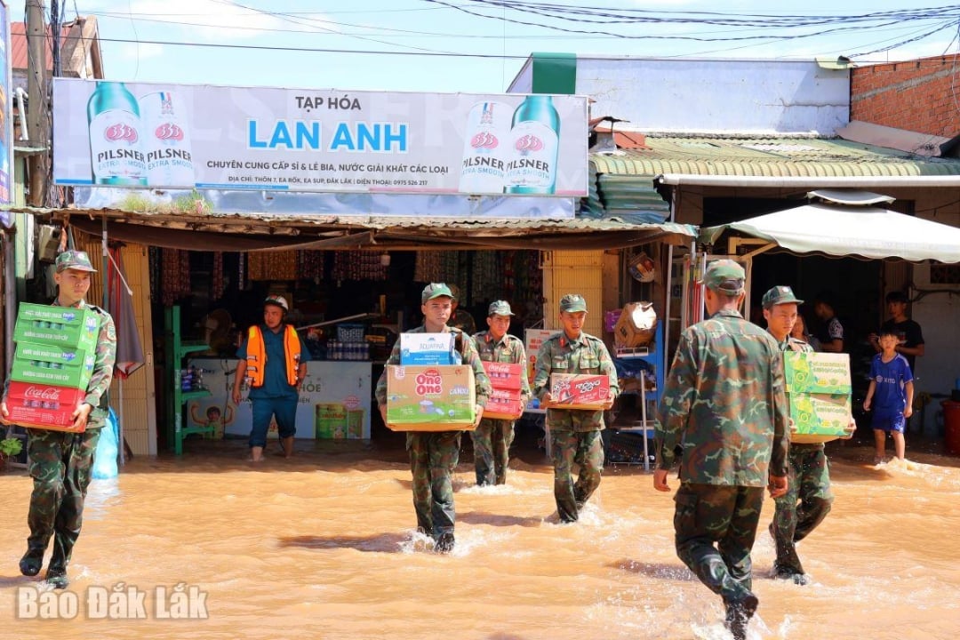 Pegawai dan tentera Kawasan Komando Pertahanan 3 - Ea Sup mengharungi air untuk membantu penduduk komune Ea Rok mengosongkan harta mereka.