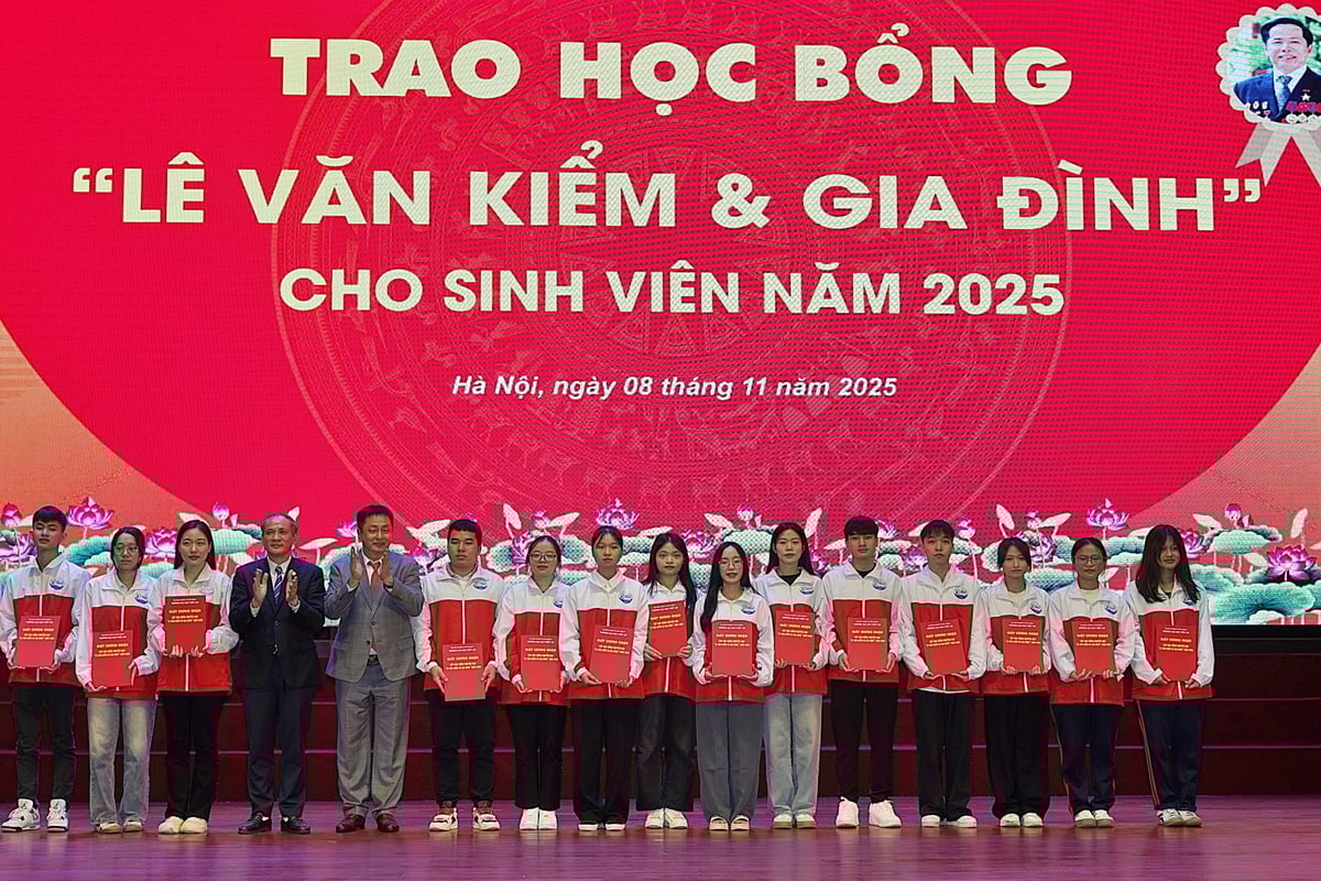 Hiệu trưởng Nguyễn Trung Việt và ông Lê Huy Hoàng trao học bổng cho sinh viên. Ảnh: Bảo Thắng.