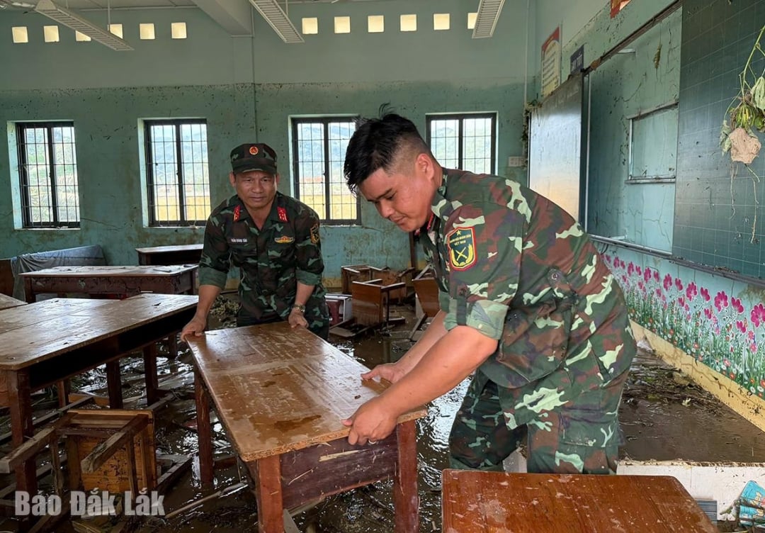 As forças armadas auxiliam nos reparos dos danos na Escola Primária de Phu Mo.