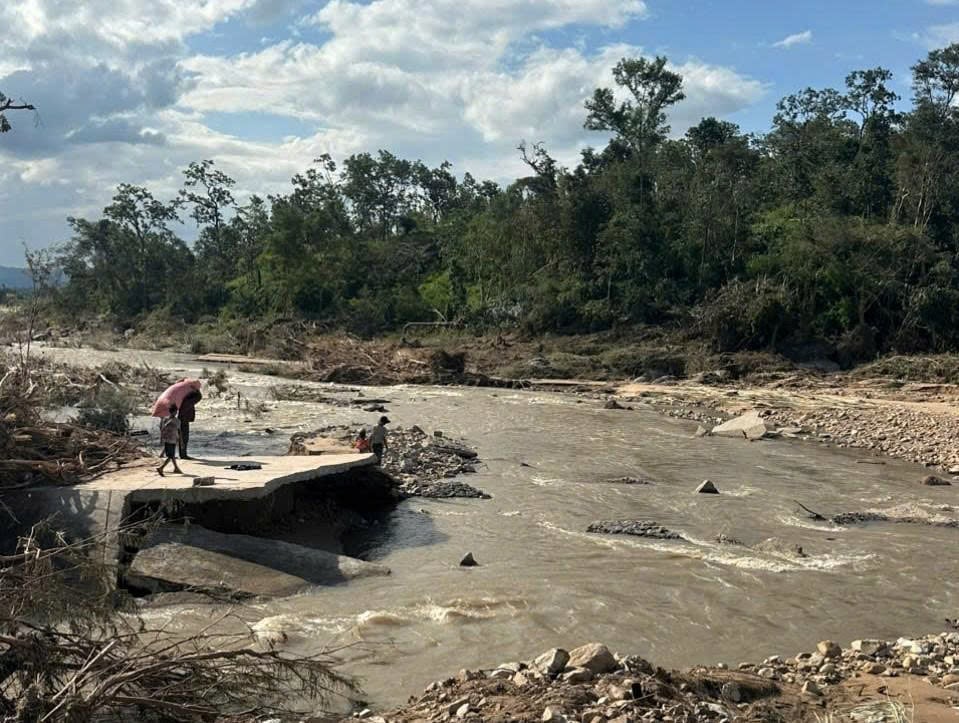 ផ្លូវបេតុងដែលនាំទៅដល់ភូមិហាច ត្រូវទឹកជន់លិចបំផ្លាញផ្ទះរាប់ពាន់គ្រួសារ។ រូបថត៖ Tuan Anh។ Đường bê tông dẫn vào làng Hrách bị lũ cuốn trôi, hàng ngàn hộ dân bị cô lập. Ảnh: Tuấn Anh.