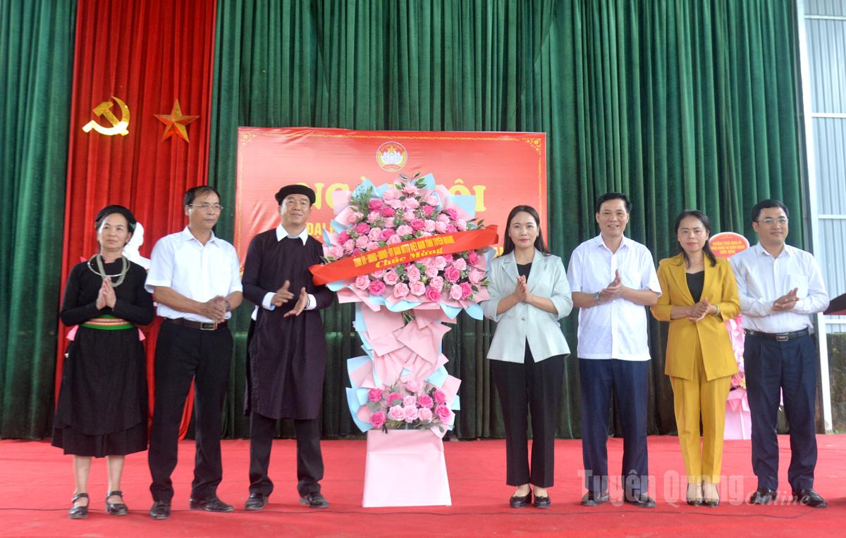 Phó Bí thư Thường trực Đảng ủy UBND tỉnh Nông Thị Bích Huệ tặng hoa chúc mừng Ngày hội Đại đoàn kết toàn dân tộc thôn Chang.