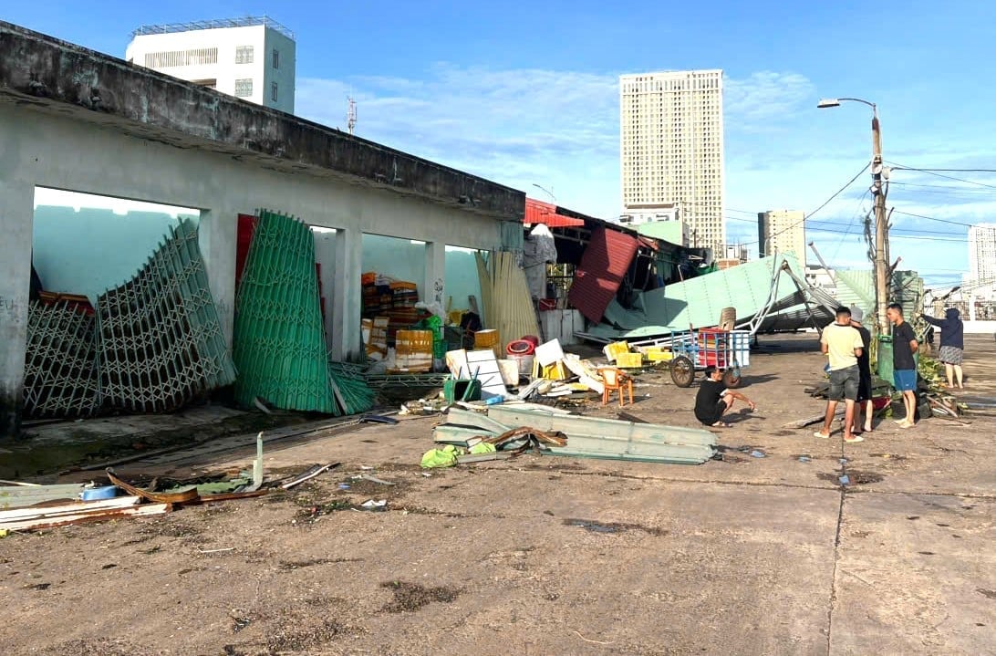 ບັນດາຮ້ານຂາຍເຄື່ອງແຫ້ງແລະຕູ້ນິລະໄພຢູ່ທ່າກຳປັ່ນຫາປາ Quy Nhon ໄດ້ມີປະຕູມ້ວນ ແລະ ປະຕູເຫຼັກແຕກ. ພາບ: CCQN. Toàn bộ kiot của các hộ mua bán tạp hoá, khay két trong cảng cá Quy Nhơn bị bung cửa cuốn, cửa sắt. Ảnh: CCQN.