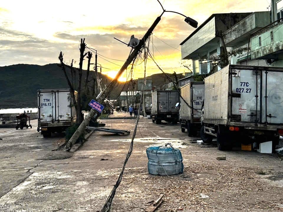 ເສົາໄຟຟ້າລົ້ມ ເຮັດໃຫ້ໄຟຟ້າ ແລະນໍ້າປະປາ ຢູ່ທ່າເຮືອ Quy Nhon ເປັນອຳມະພາດ. ພາບ: CCQN. Trụ điện gãy đổ khiến điện nước tại cảng cá Quy Nhơn bị tê liệt. Ảnh: CCQN.