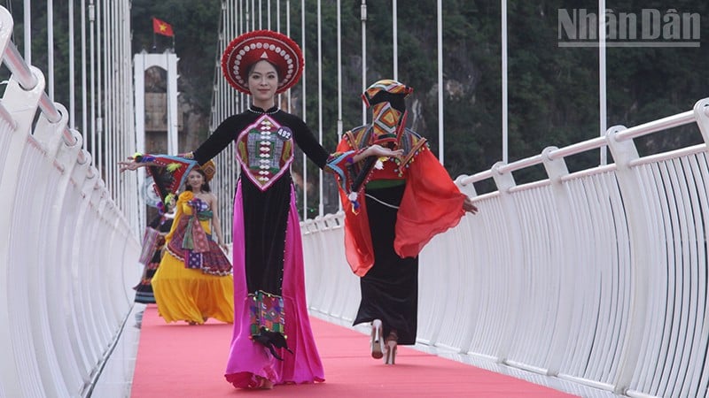 អ្នកចូលរួមក្នុងការសម្តែងសំលៀកបំពាក់ជនជាតិភាគតិចនៅស្ពានកញ្ចក់ Bach Long ដែលវែងជាងគេលើពិភពលោក។