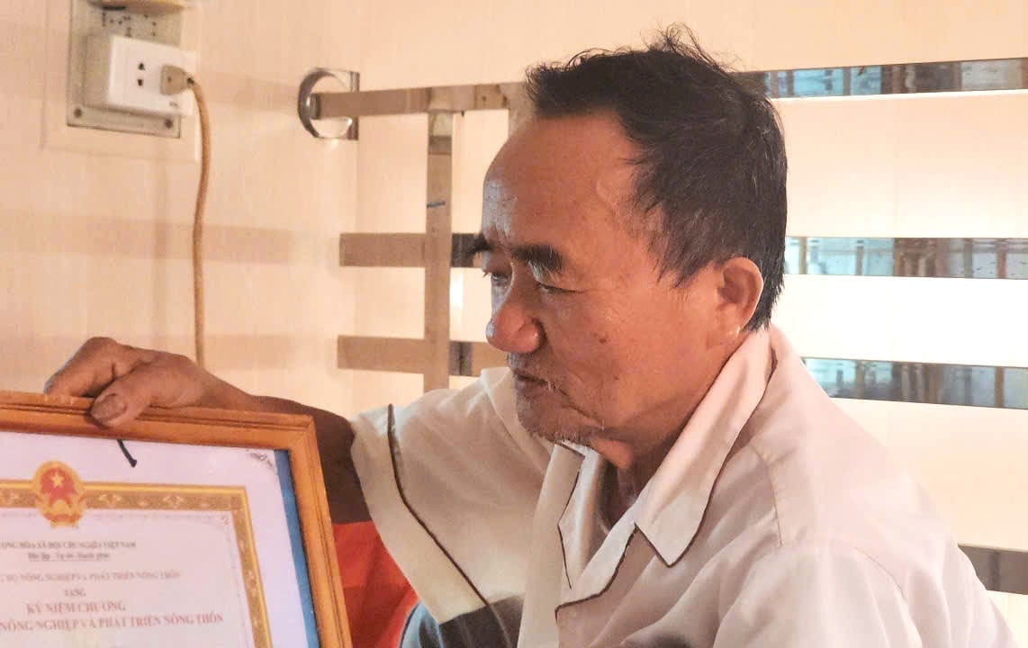 Ông Phạm Hồng Thưởng lục lại kỷ niệm chương của Bộ Nông nghiệp và Phát triển nông thôn (nay là Bộ Nông nghiệp và Môi trường) cùng những bằng khen, giấy khen như thay cho lời ghi nhận của Đảng và Nhà nước cho bản thân ông cũng như cán bộ, đảng viên, nhân dân xã Đoàn Xá (cũ). Ảnh: Đinh Mười.