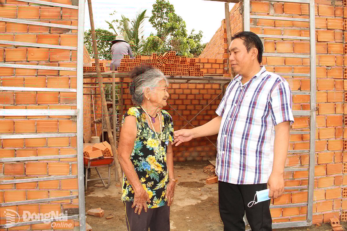 Ông K’Luận, Trưởng ban Công tác Mặt trận ấp 4, xã Tà Lài thăm hỏi bà Ka Tờ trong quá trình hoàn thiện căn nhà kiên cố do Nhà nước hỗ trợ kinh phí xây dựng. Ảnh: Văn Truyên

