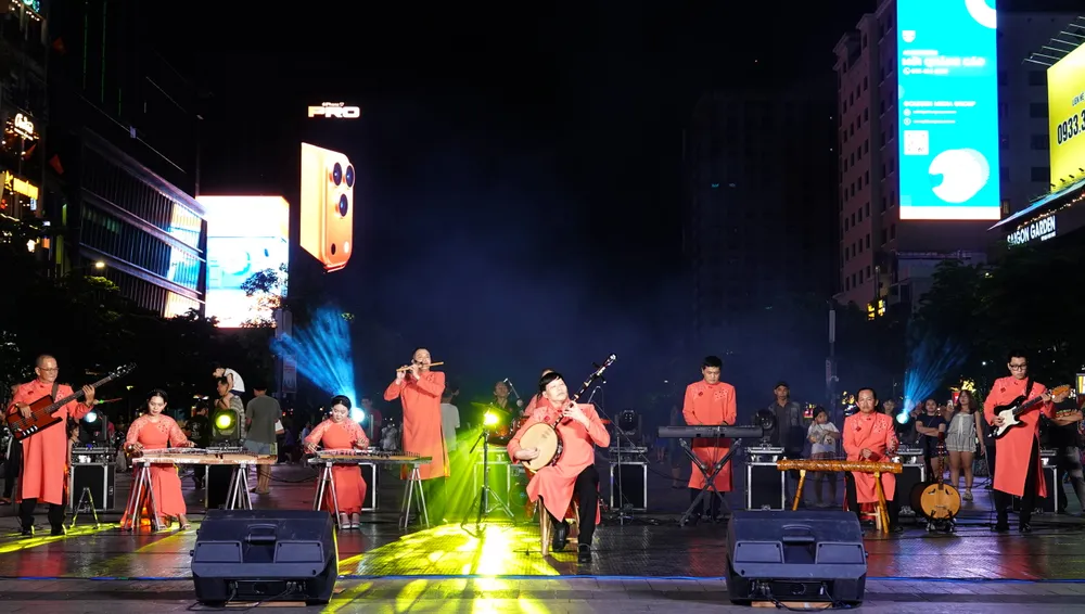 NSƯT Anh Tấn biểu diễn cùng dàn nhạc dân tộc Nhà hát Ca múa nhạc dân tộc Bông Sen trong tiết mục độc tấu đàn kìm "Ngẫu hứng sen". Ảnh: THÚY BÌNH