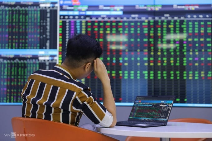 Inversores consultan los paneles electrónicos de precios en una empresa de valores de Ciudad Ho Chi Minh. Foto: Quynh Tran