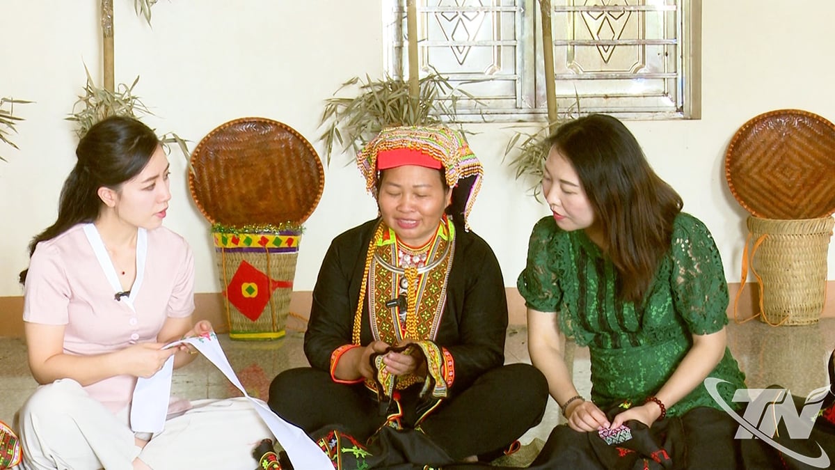 सुश्री ट्रियू थी थोआ (मध्य में) पर्यटकों को पारंपरिक पोशाक कढ़ाई तकनीक से परिचित कराती हैं।